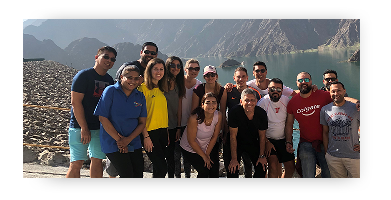 Group of employees standing in front of a mountain in United Arab Emirates